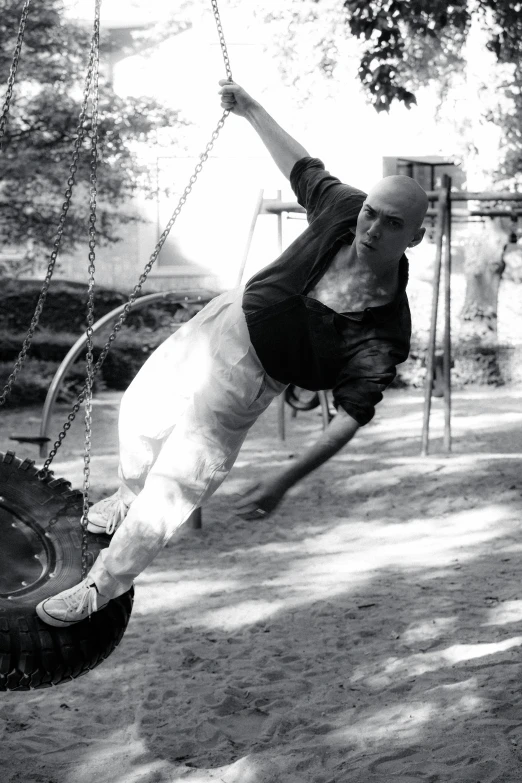 a man playing on a tire swing