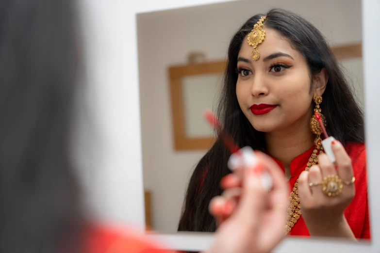 a woman looks in a mirror at her own reflection