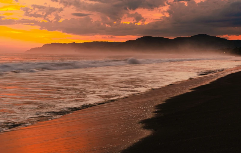 an orange and yellow sunset at the beach