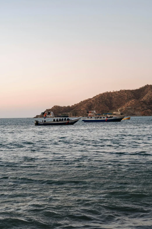 some boats in the water near some mountains