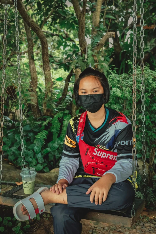 woman in safety equipment on swing with face mask