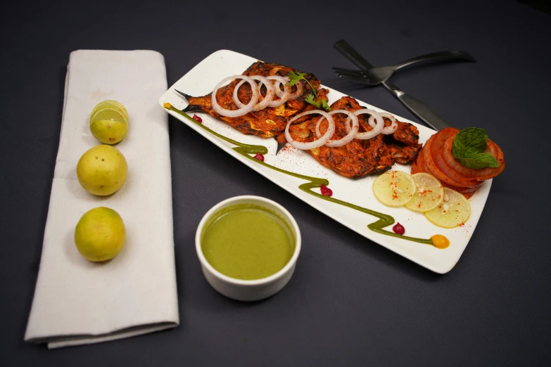 a plate of food on top of a table next to three apples