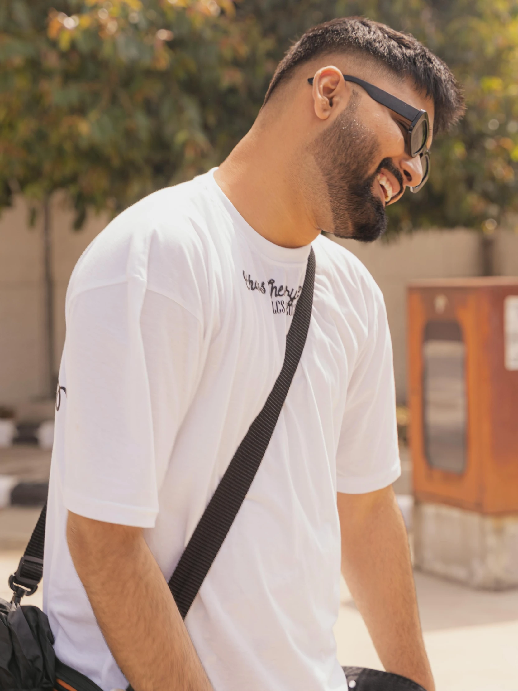 a man with a camera bag walking down the street