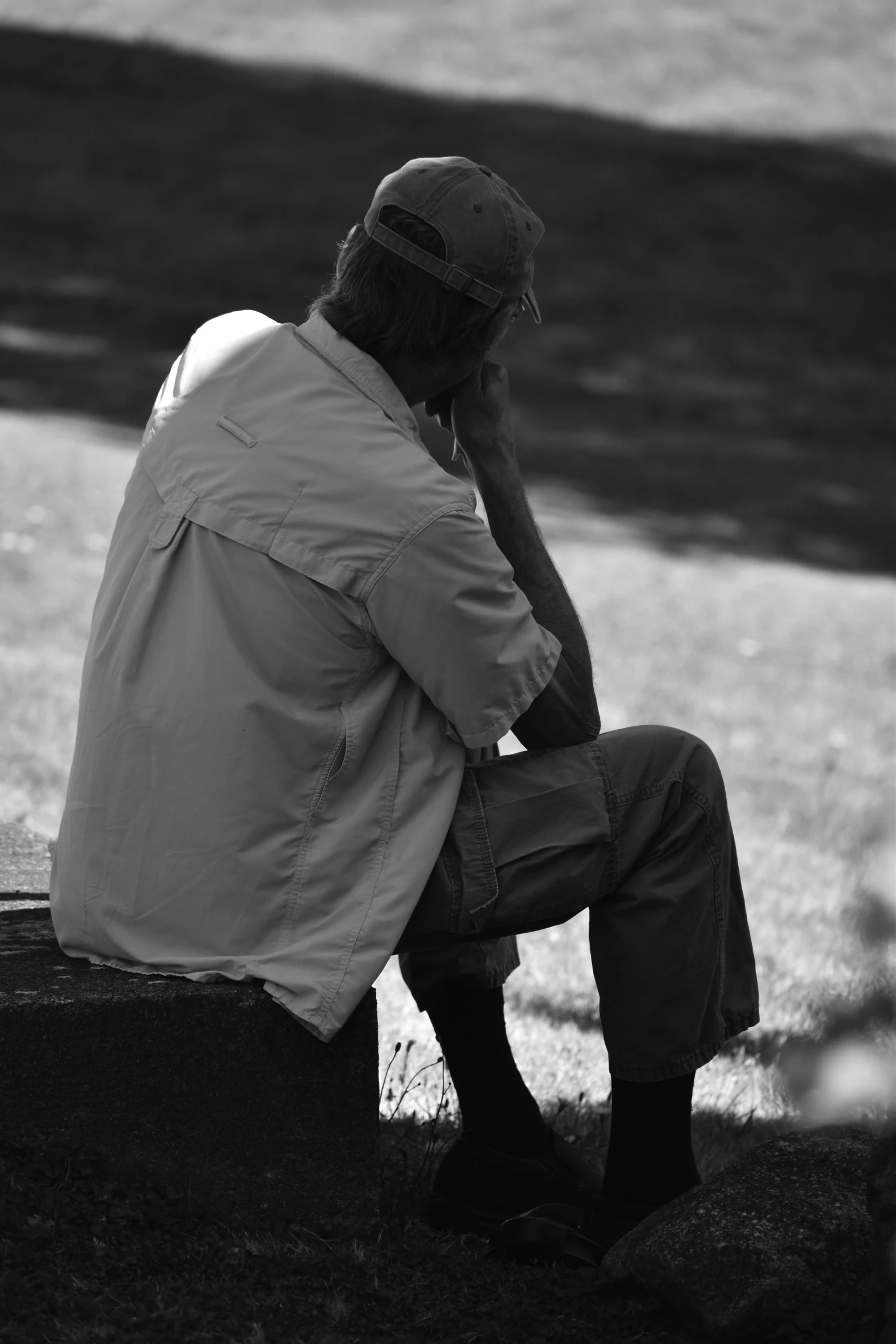 the man is sitting down while talking on his cellphone