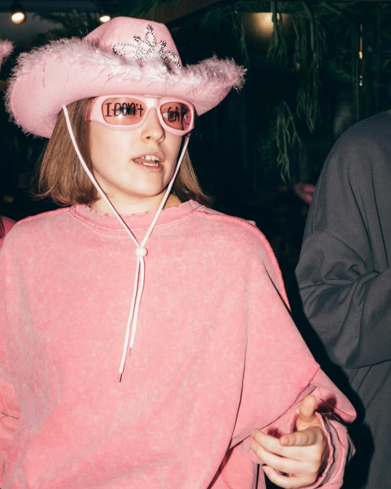 woman with pink hat and sunglasses with white fuzzy trim