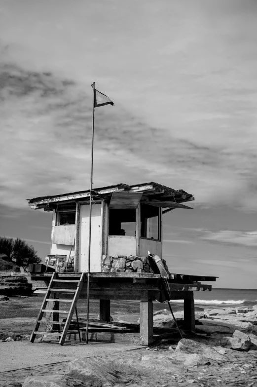 a lone tower like structure with a ladder on the beach