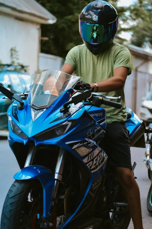 a man is on top of his blue motorcycle