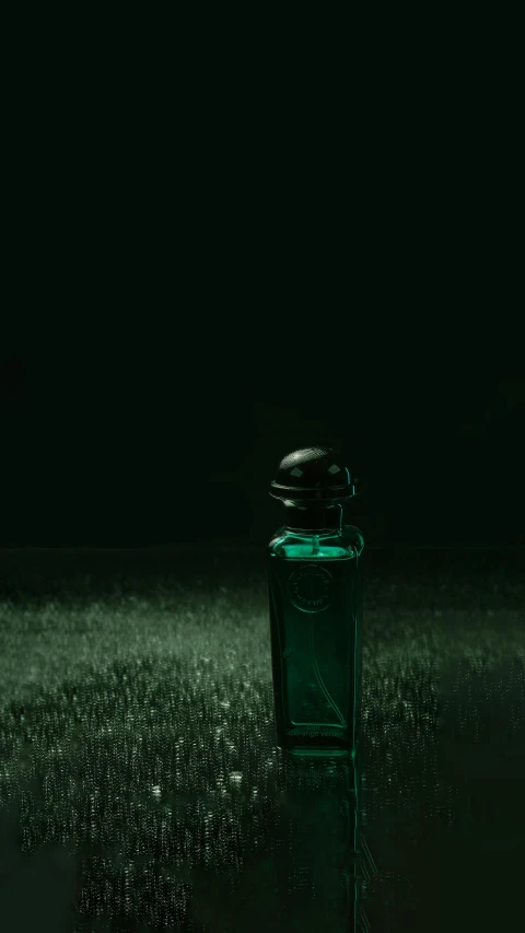 a green bottle sitting on the ground in the middle of the night