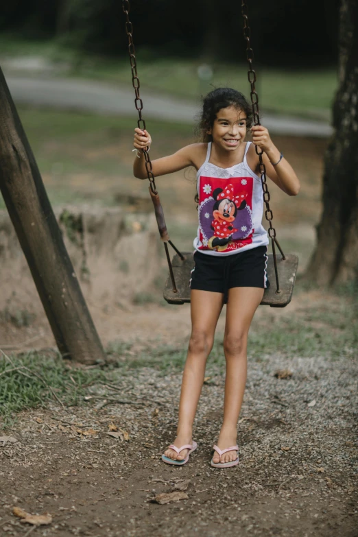 little girl on a swing with mickey mouse t - shirt