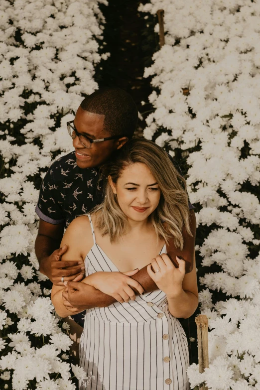 an african american couple emcing each other in a field of white flowers