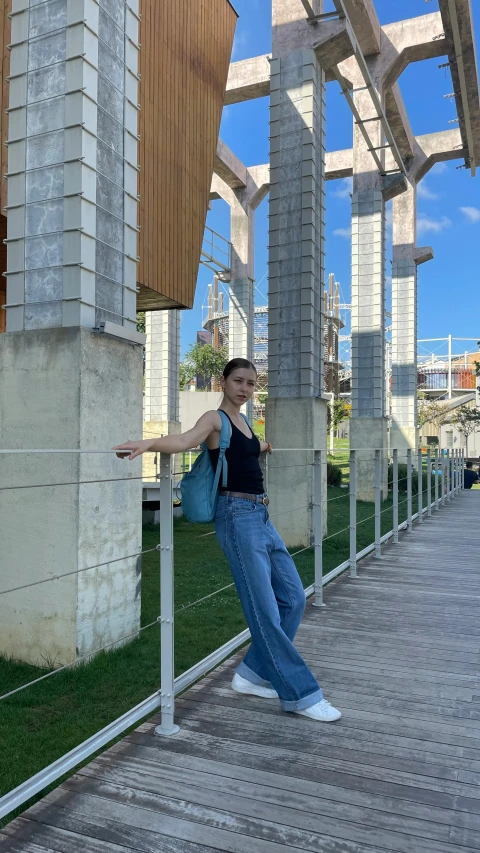 a person leaning on a fence by an area of grass