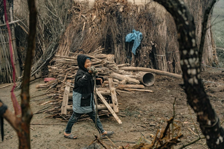 man taking po of wood pile in woods