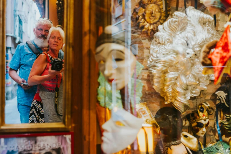 the man and woman are posing in front of the mirror