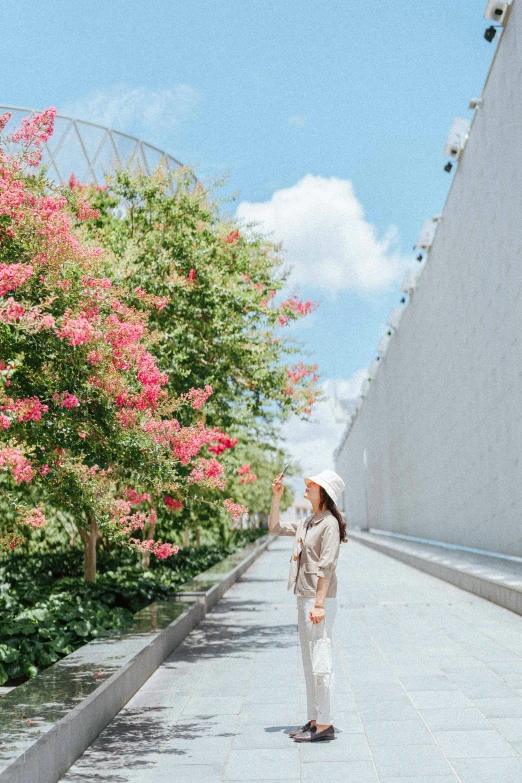 woman with an umbrella taking a po on the sidewalk