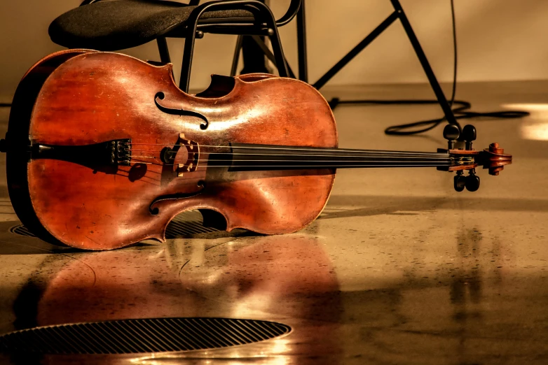 an old violin is laying next to a chair