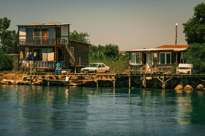 some houses sit on the water by a bridge