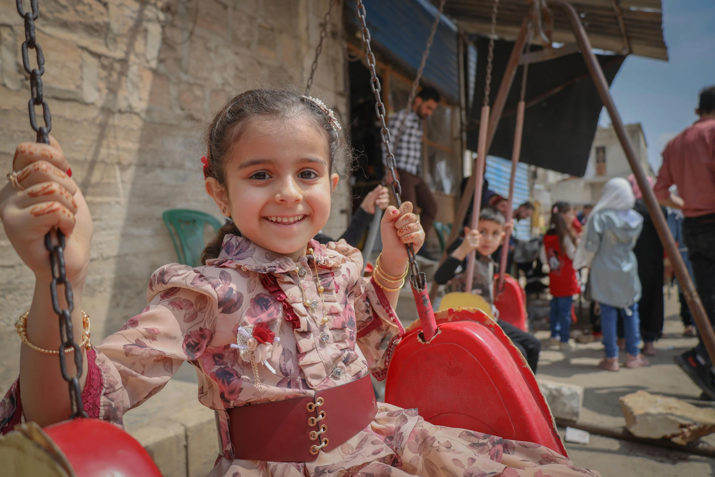 little girl sitting on swing in outdoor area