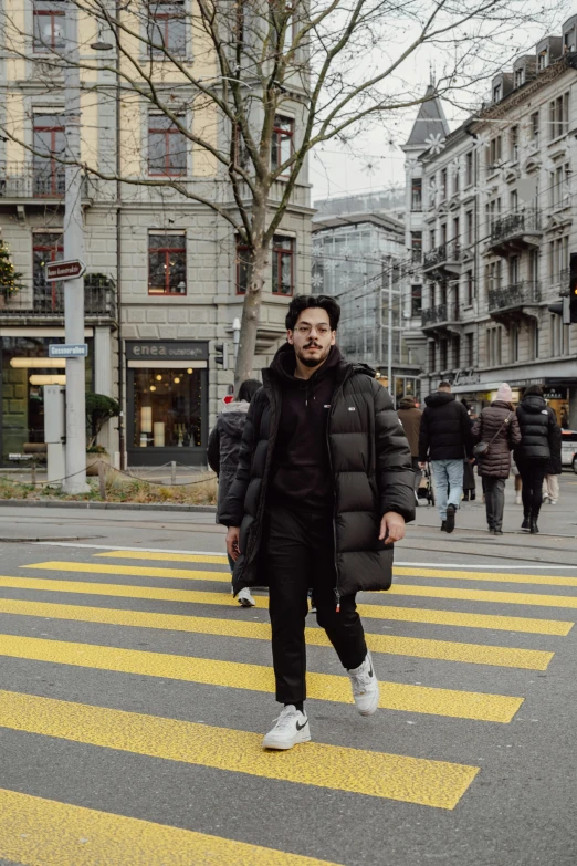 a man in the city standing on the crosswalk