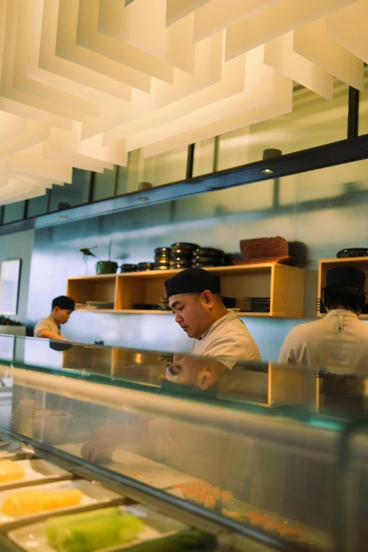 two chefs preparing food in a kitchen inside of a restaurant