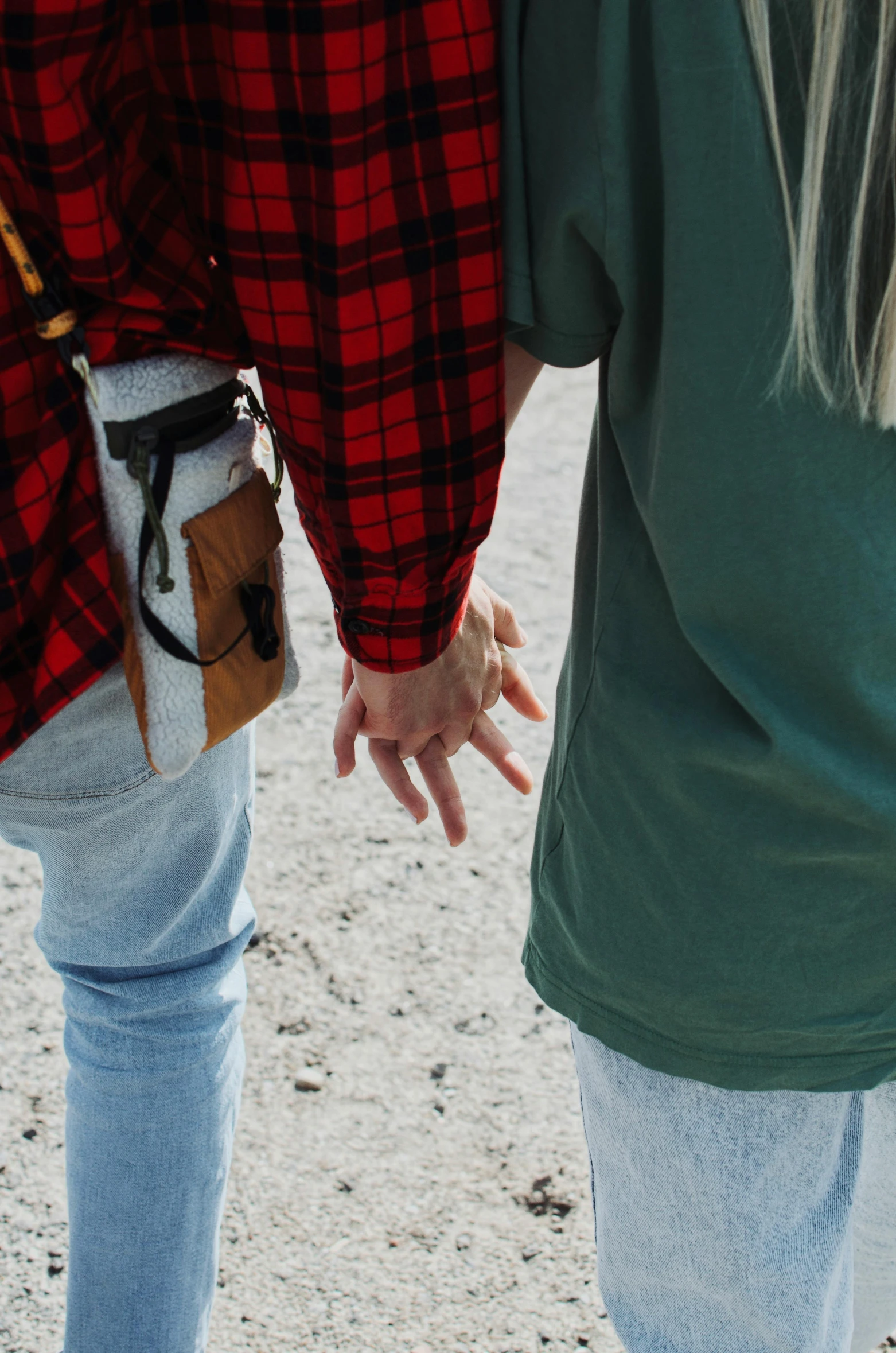 two people hold hands while walking across a field