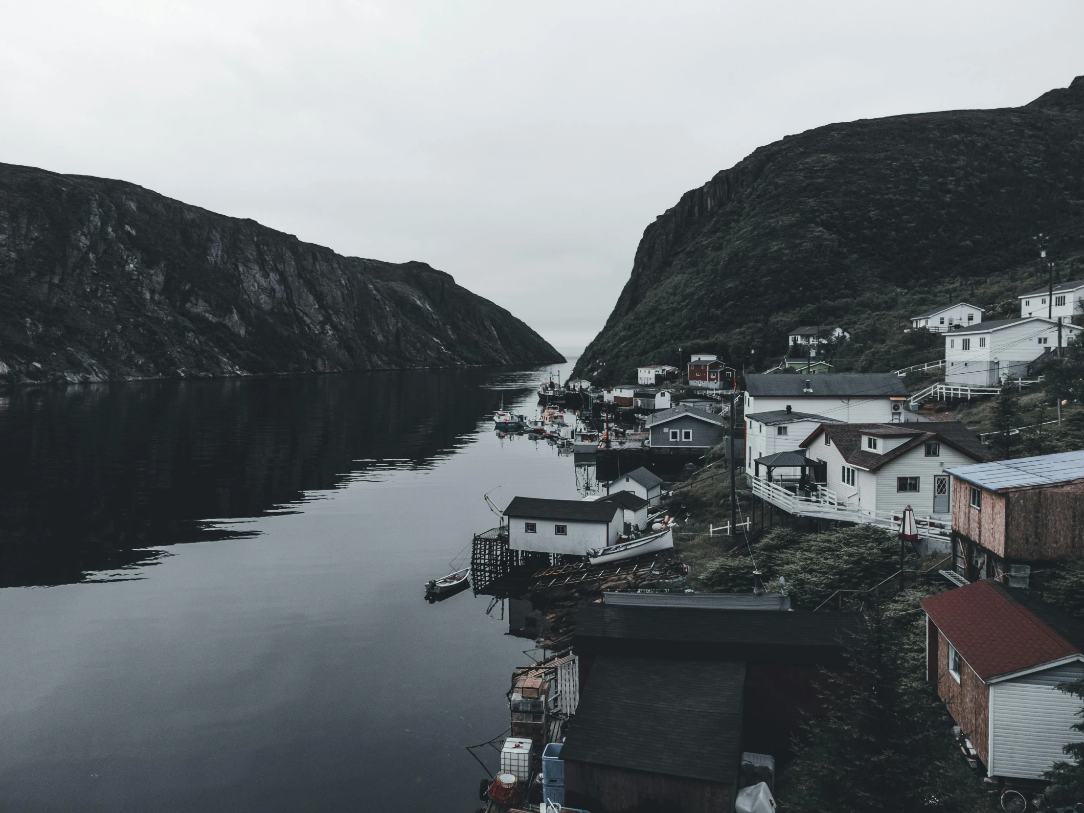 a body of water with a town and a hill in the background