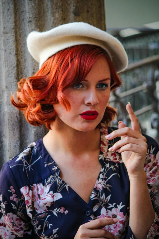 the woman has a red hair and wearing a hat