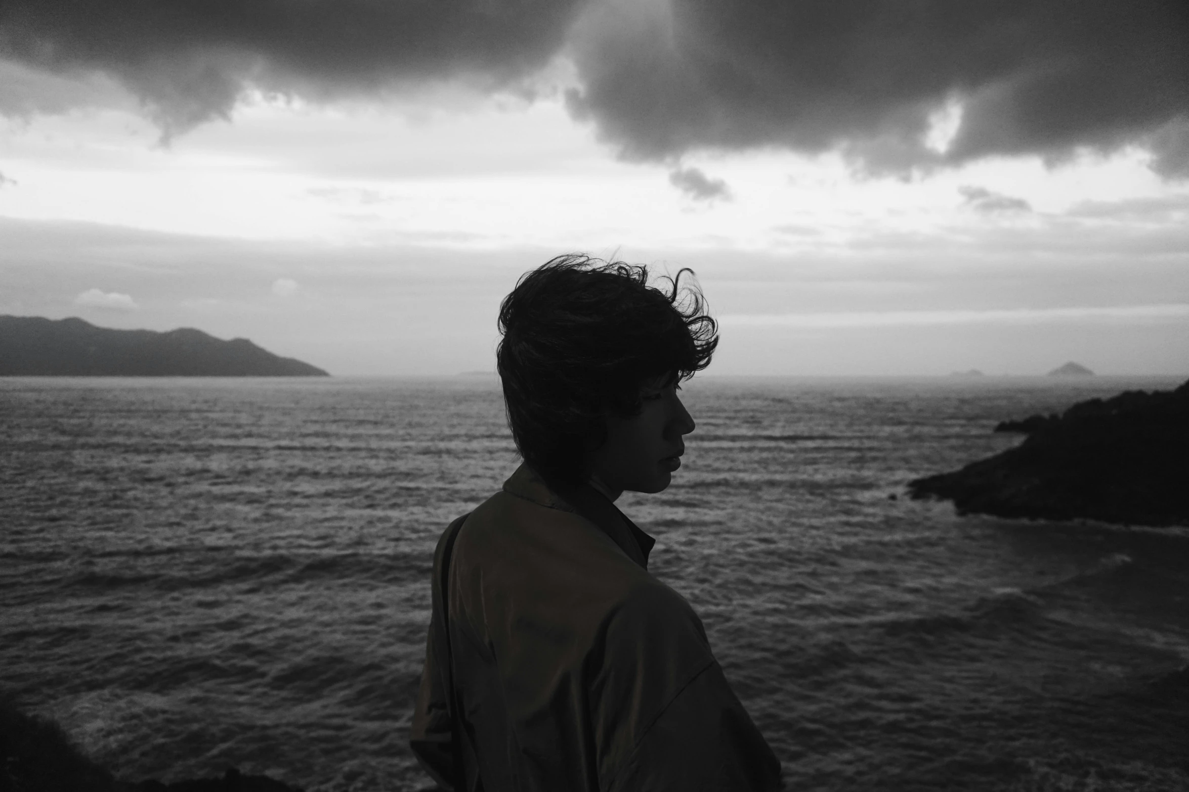 a person with a very long hair looking at the water