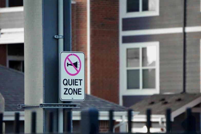 a street sign that says quiet zone zone next to the side of a building