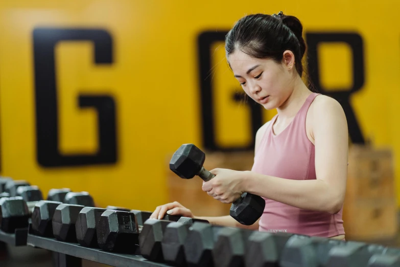 a woman in a gym works on a bar