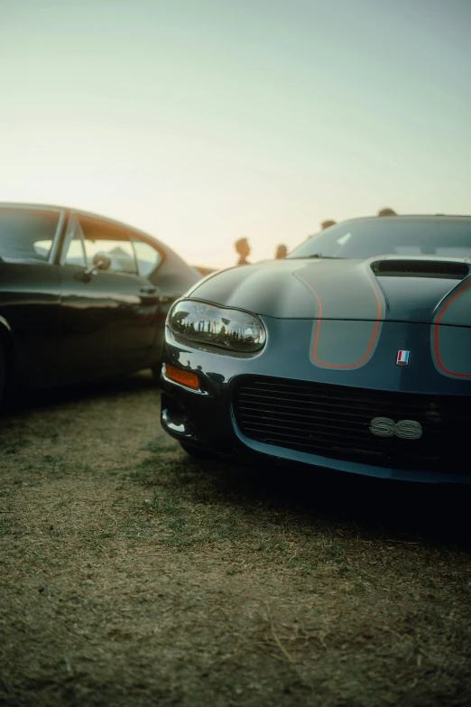 two parked cars sitting on top of a sandy beach