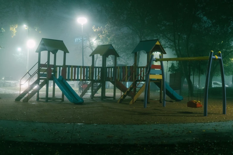 a wooden playground playset in the dark