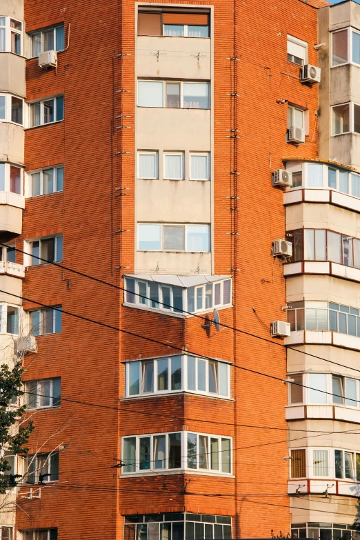 a bus drives past tall orange buildings with balconies