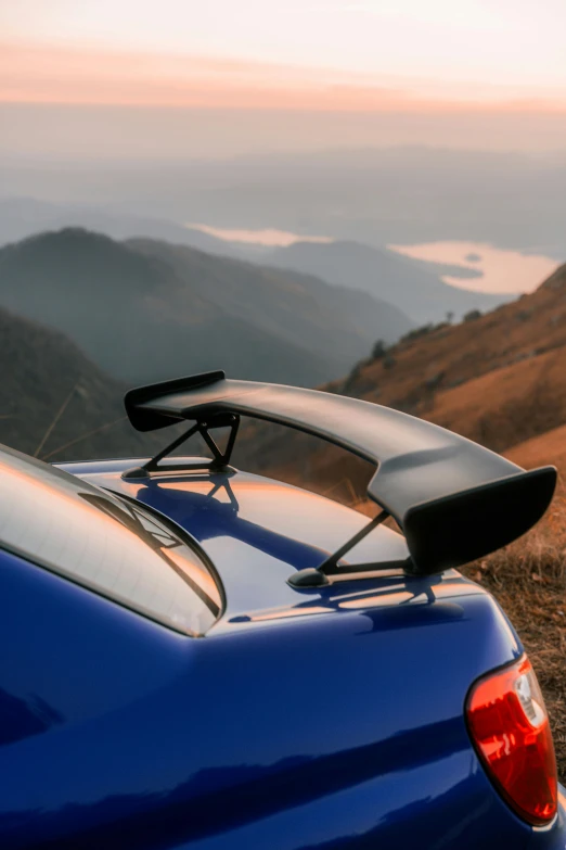 a surfboard on the back of a blue sports car