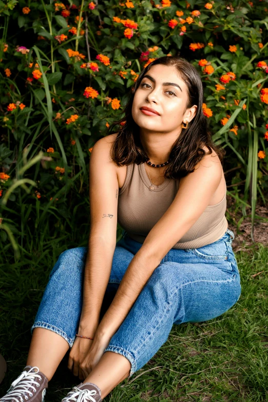 a woman sitting in the grass with her feet crossed