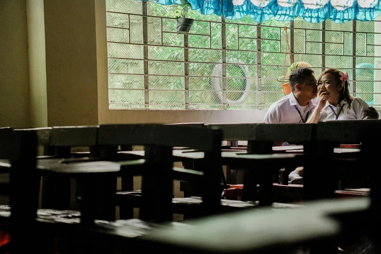 two children sitting in a school room near the windows