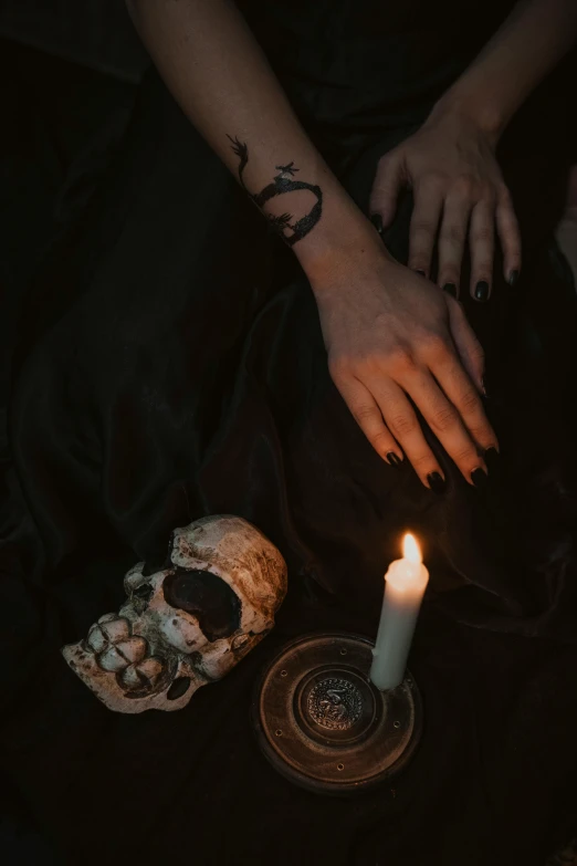 a person is holding on to a candle and its shadow is on the ground