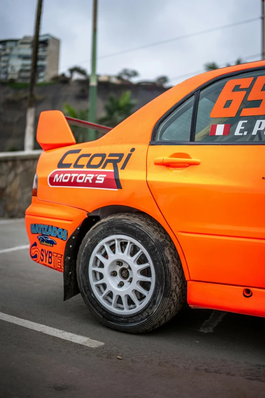 an orange car with its tire on the road