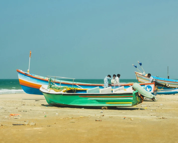 three colorful row boats on the beach during the day