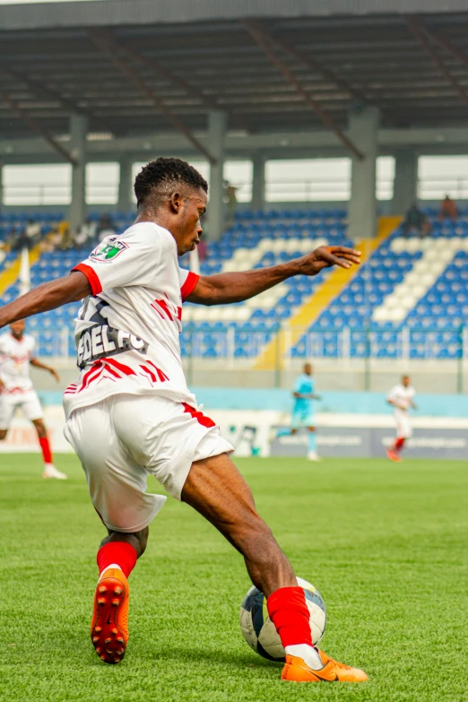 an african american soccer player kicks the ball during a game