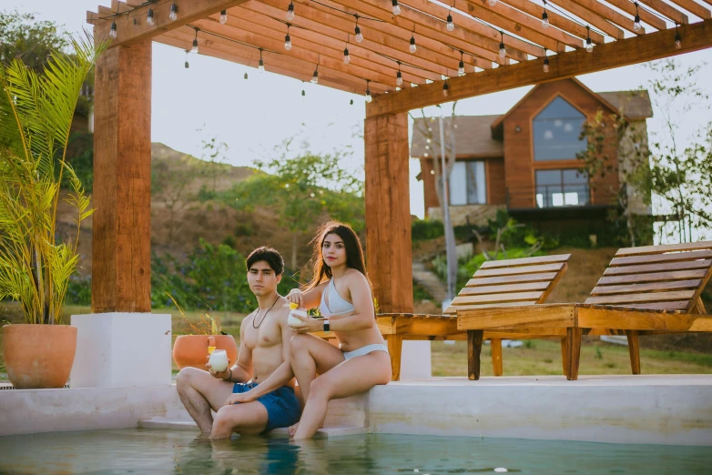 a couple having a good time in a pool at the house