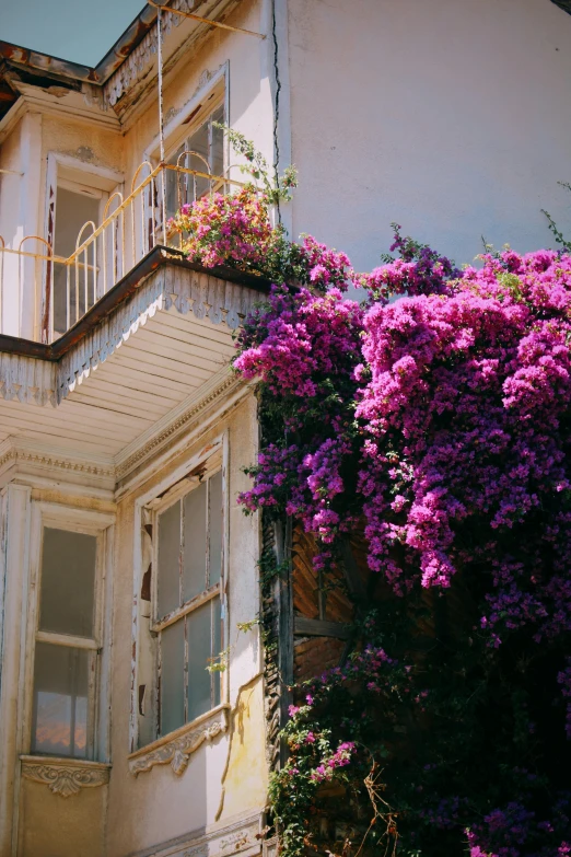 a small building with two balconies filled with flowers