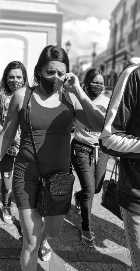 people wearing masks walking down the street