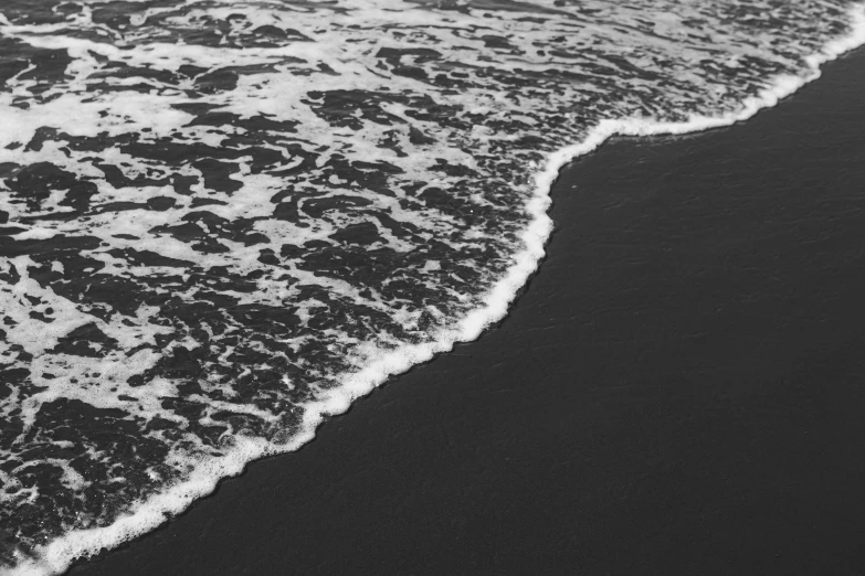 an ocean wave crashing to the shore at a beach