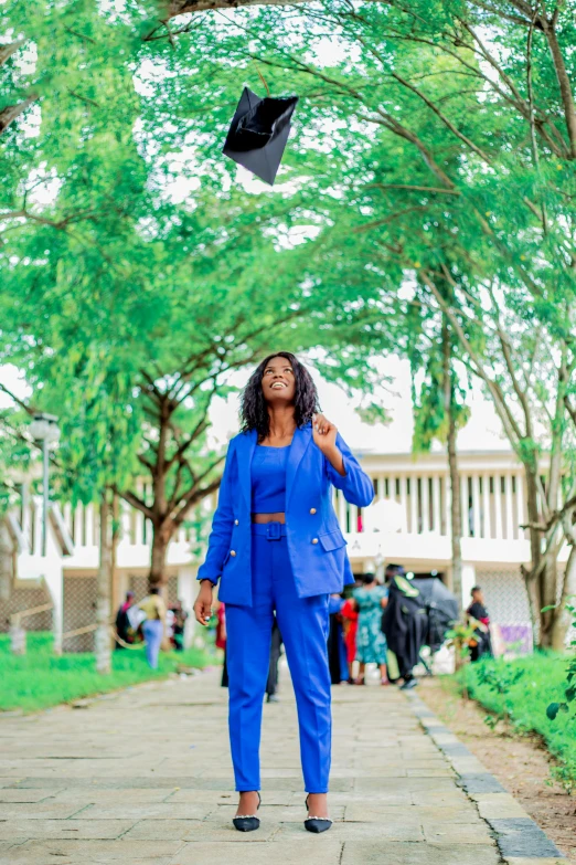 a woman standing on a path under a graduation cap