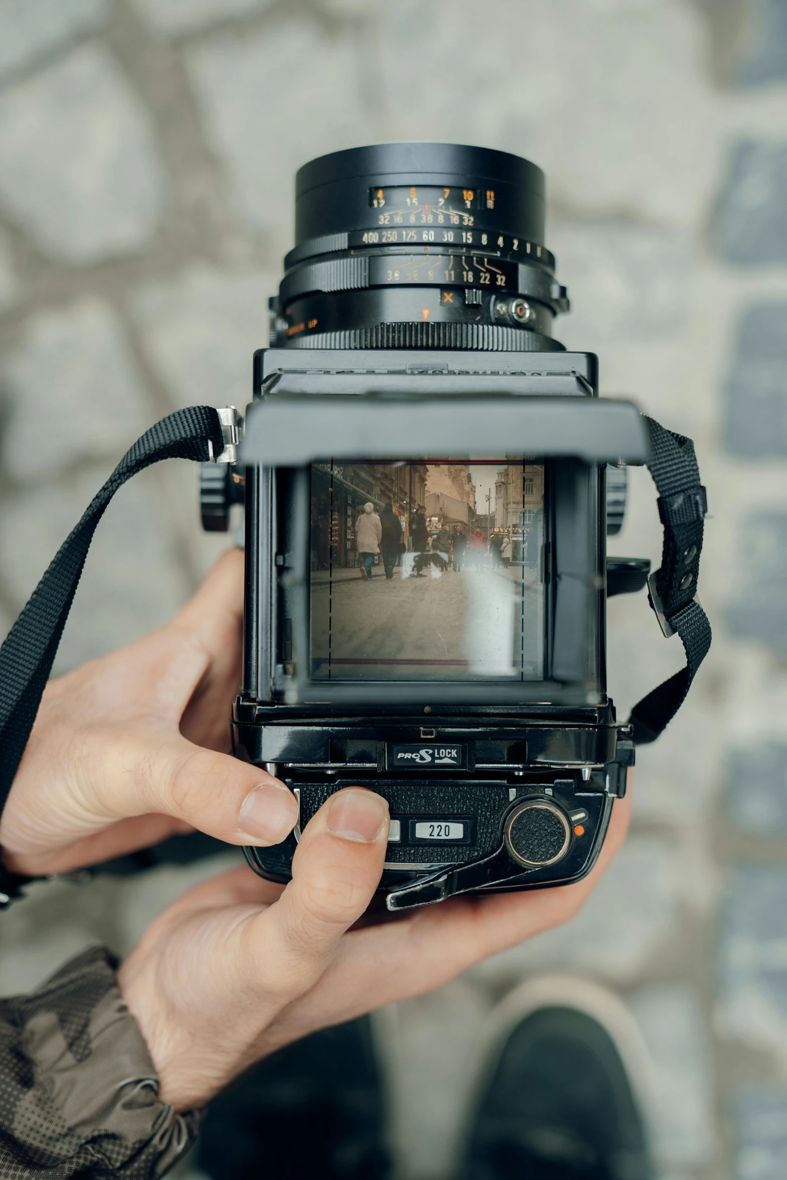 someone is holding an old fashioned camera up to a screen