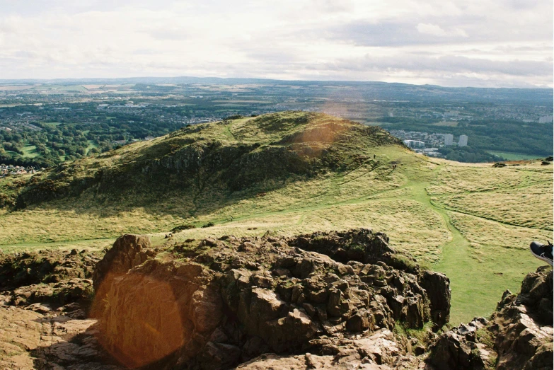 a man riding a horse on top of a grass covered mountain