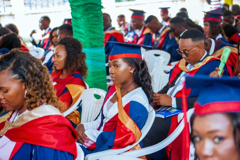 graduates in caps and gowns sitting in a line