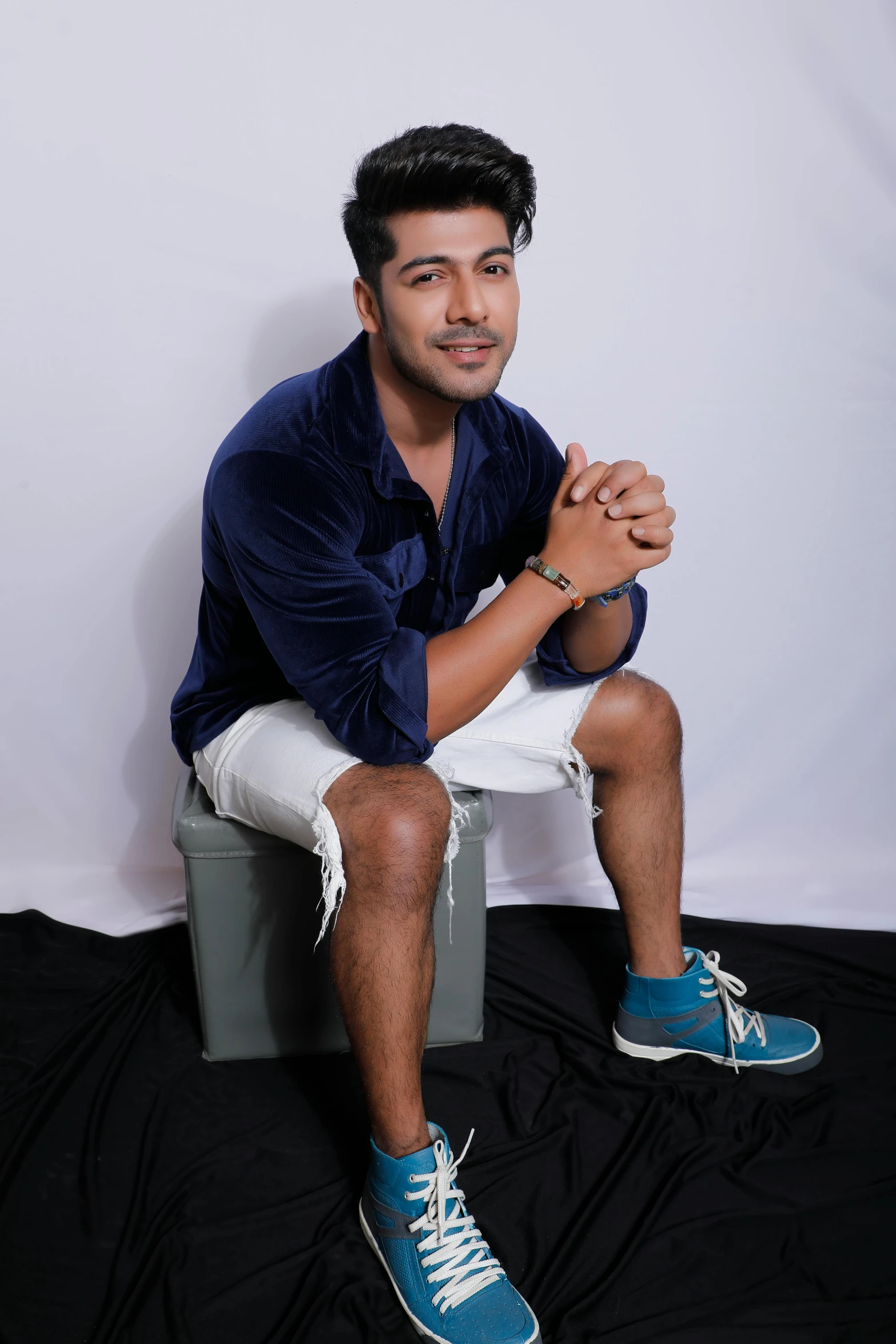 a man posing for a picture sitting on top of a chair