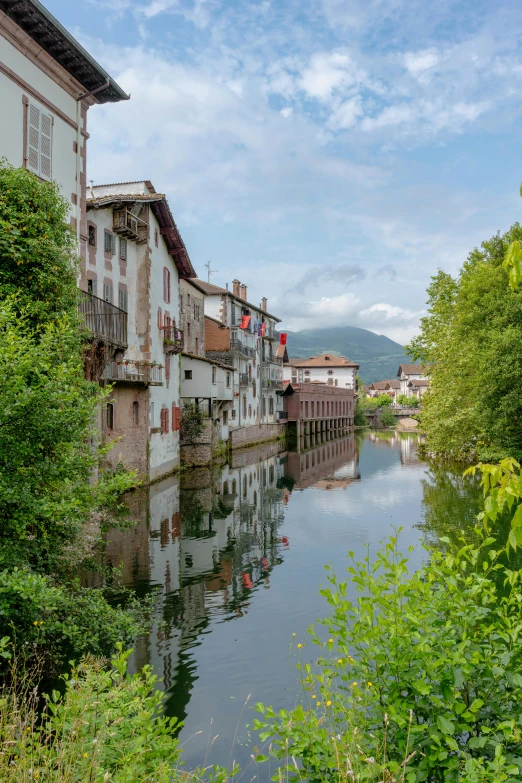 the water is calm in front of a row of buildings