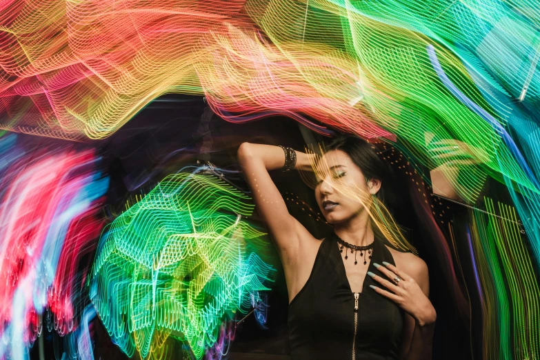 a woman is posing in front of colorful lights